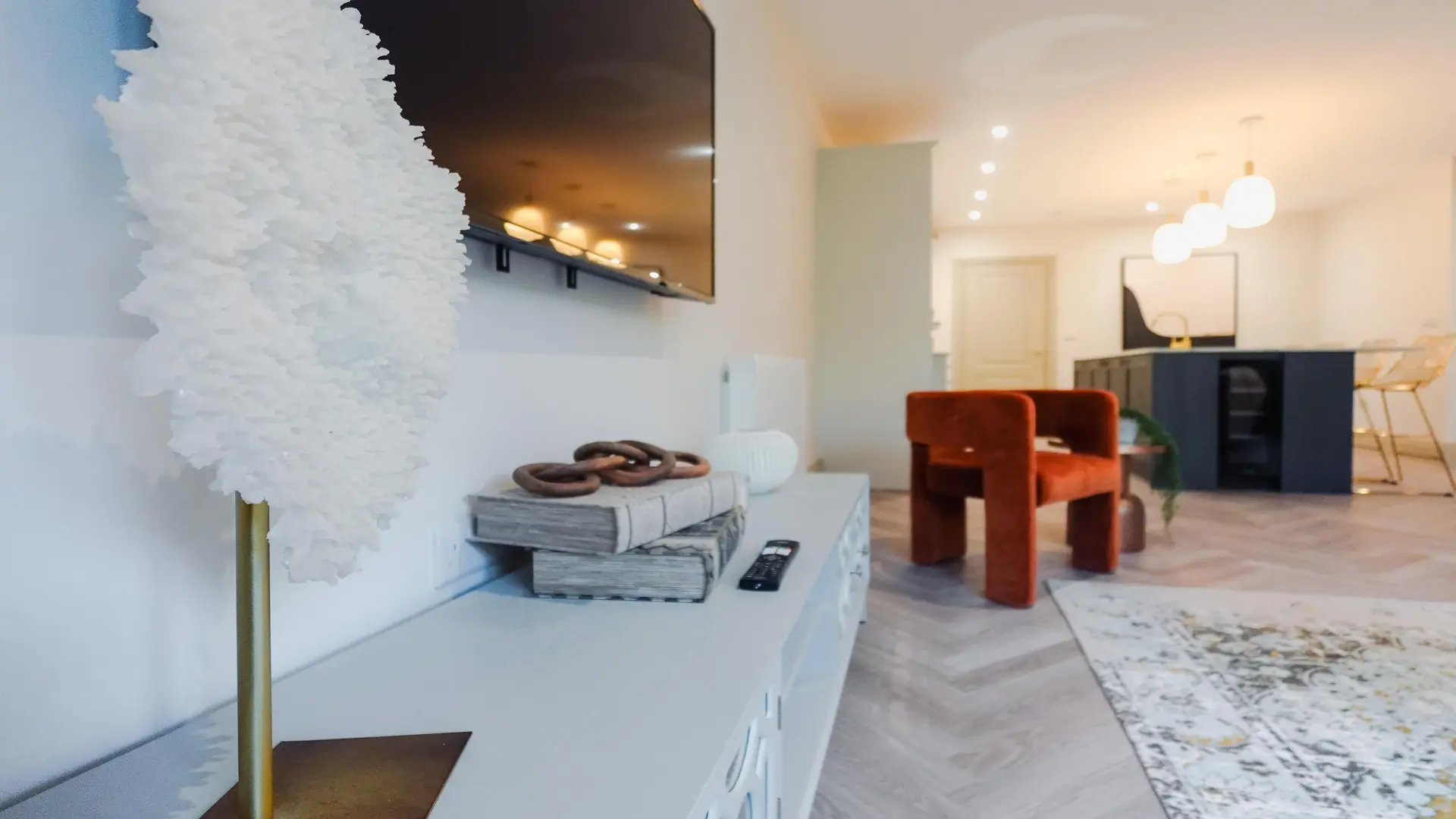 Modern open-plan living room with stylish decor and a blurred kitchen in the background