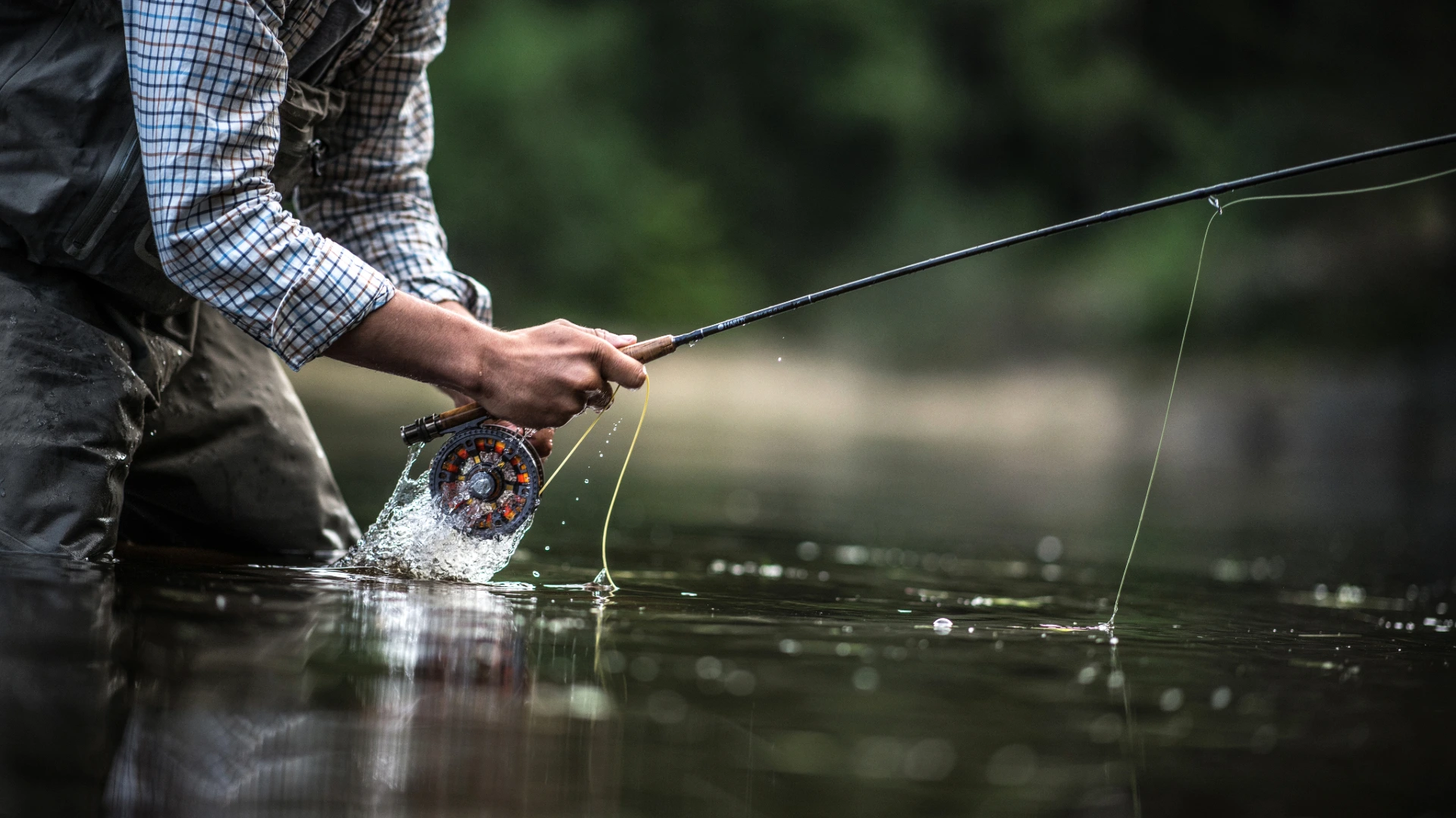 Man fishing in the River Test, enjoying the peaceful surroundings of Mottisfont, Hampshire