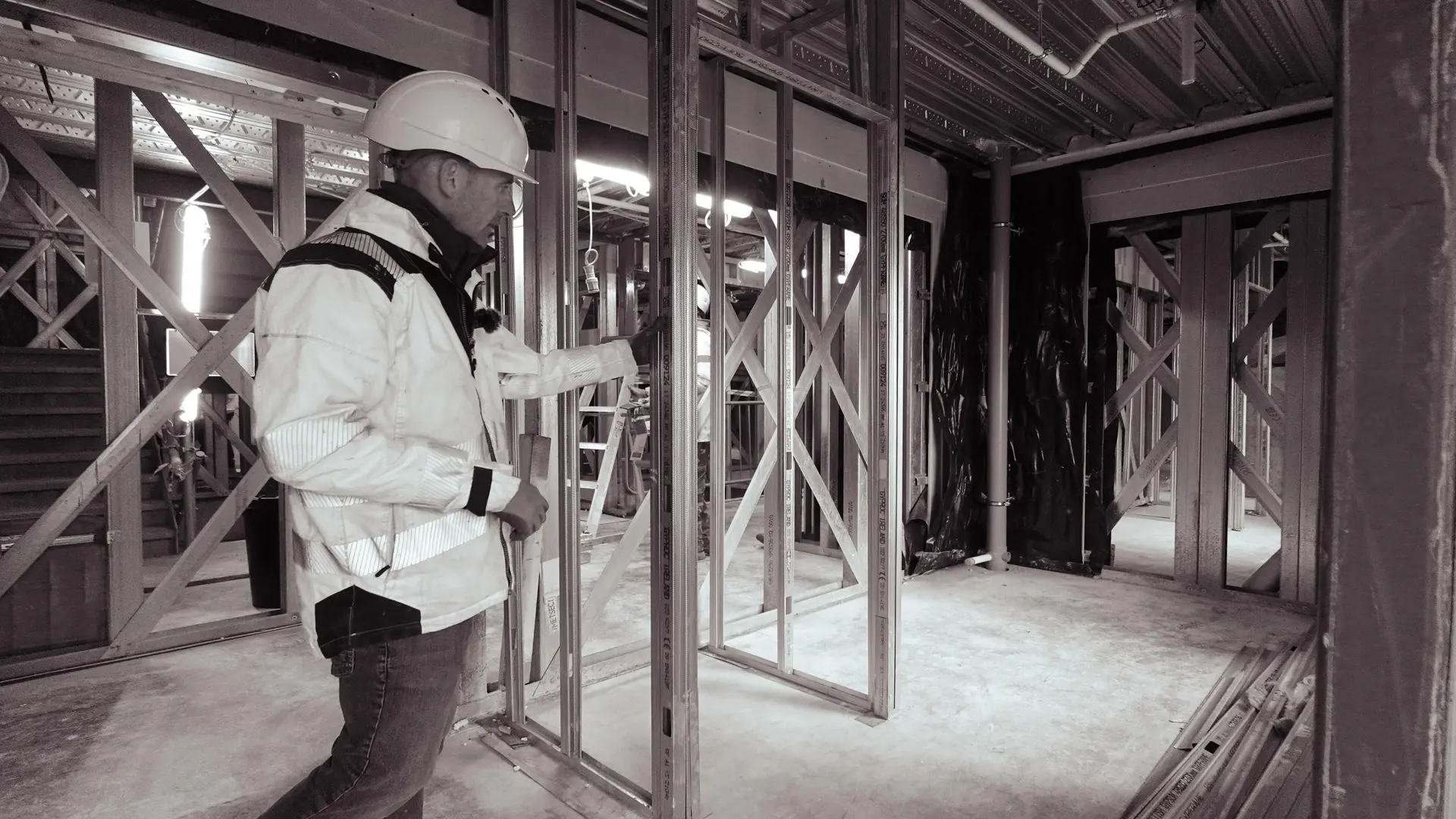 Site manager overseeing construction inside the building, surrounded by Metsec panels.