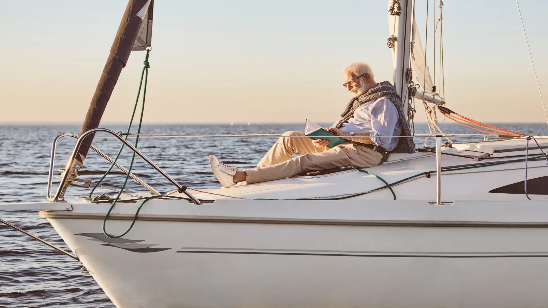 Man reading on a boat, finding peace and clarity during the psychological impact of downsizing, focusing on personal well-being.